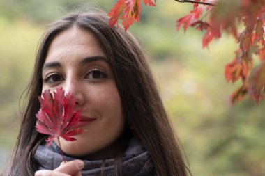 Ellerinde yaprak olan genç bir kadın.