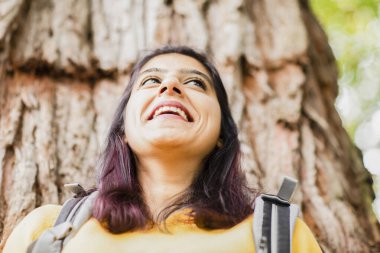 Genç bir kadın bir ağacın önünde
