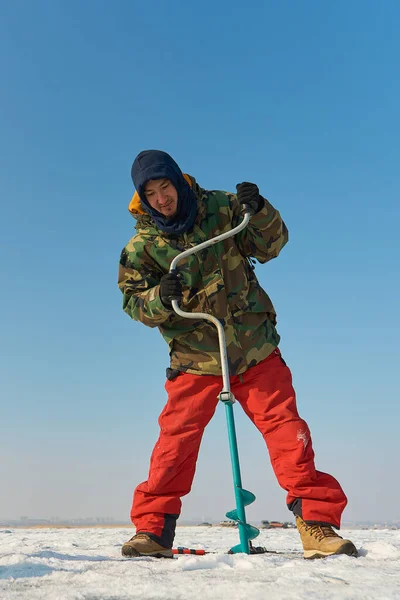 Warmly Dressed Asian Guy Drills Hole Ice Winter — Stock Photo, Image