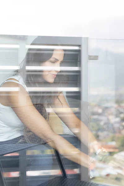 窓からの眺めを通して働く若い女性 — ストック写真