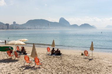 Copacabana Sahili 'ne güzel güneşli manzara ve Rio de Janeiro, Brezilya' daki dağlar