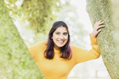 Genç kadın ağaçların arasında