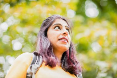 Parkta yürüyüş yapan genç bir kadın. 