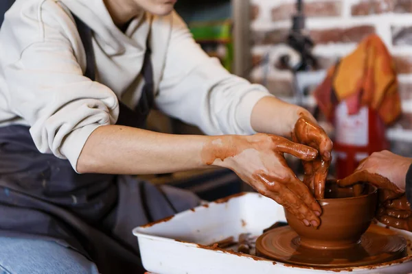 陶芸家と陶芸家の車輪の上の学生は粘土から料理を作る — ストック写真
