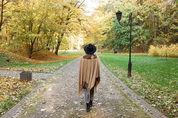 Siyah Şapkalı Pançolu Kahverengi Saçlı Kadın Sonbahar Parkında Yürüyor — Stok fotoğraf