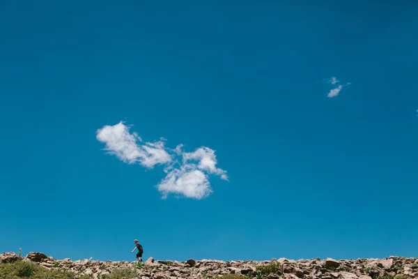 Menino Caminhando Caminhada Colina Rochosa Com Céu Azul Sol — Fotografia de Stock