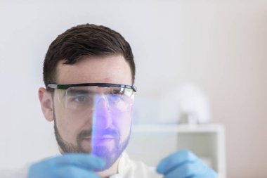 Scientist male with lab glasses working in a laboratory clipart