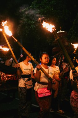 Young Balinese girls with torches at the Ogoh-Ogoh parade clipart