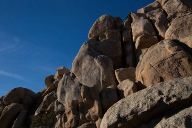 Sunlit granite giants stand tall under Joshua Tree's sky clipart