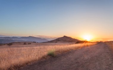 Kertenkele Tepesi 'nde gün batımı parıltısı, Kaliforniya' da yürüyüş patikası.