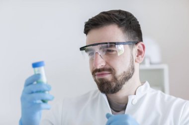 Scientist male with lab glasses working in a laboratory clipart