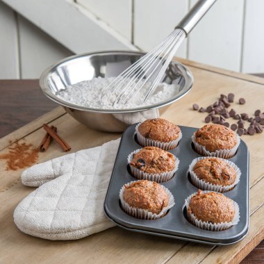 Mutfak tezgahında taze kekler ve pişirme malzemeleri.