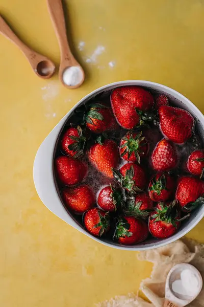 用小苏打和木头把草莓放在一个白碗里洗 — 图库照片