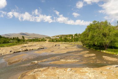 Arkasında bulutlu bir gökyüzü olan bir nehir.