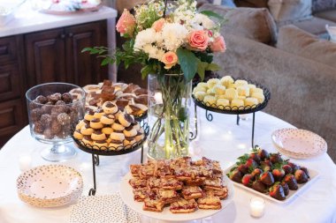 Tatlı masasını çiçeklerle süsleyip çeşitli şekerlemelerle donatın.