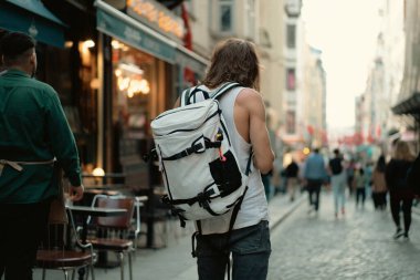 Sırt çantalı bir turist şehirde dolaşıyor..