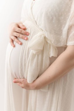 Müstakbel krem rengi noktalı elbiseli annenin yakın çekimi.