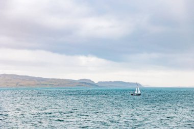 Choppy 'de yelkenli, bulutlu bir günde Teal Water