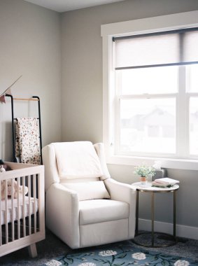 Serene nursery with armchair and crib by sunlit window clipart