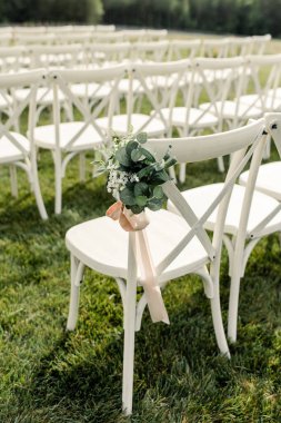 Çimlerin üzerinde beyaz düğün sandalyelerinin yakın çekimi