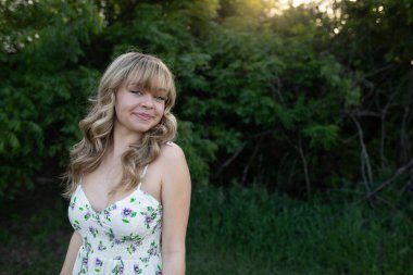 Genç bayan sahada, parlak beyaz elbiseli.