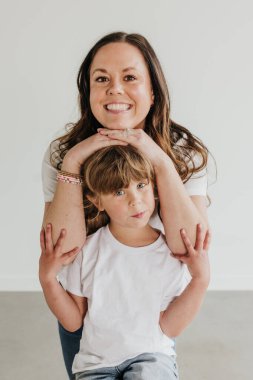 Anne ve kızının şakalaşarak birbirlerine yaslanmaları.