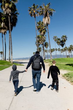 Uncle & Nephews on Boardwalk in Venice Beach, CA clipart