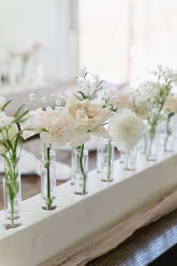 Düğün resepsiyonunda masa dekoru olarak tek kök tomurcuk vazoları