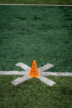 Bir futbol sahasında turuncu bir koni..