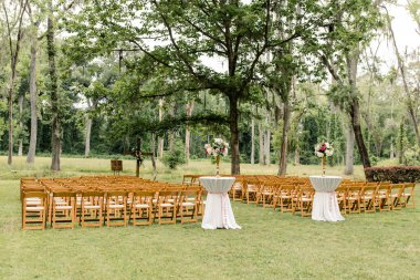 Sandalyeler ve çiçeklerle kurulmuş açık hava düğün törenleri.