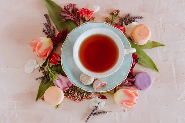 Stock image Elegant tea setup with macarons and fresh spring flowers