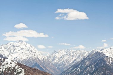 Himalayan snow capped mountain peaks with blue skies clipart