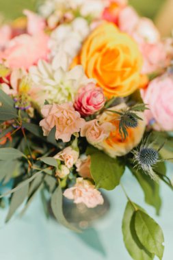 Tropikal düğün için renkli masa çiçeği düzenlemesi