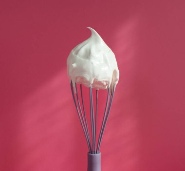 Pembe arka planda çırpılmış krema.