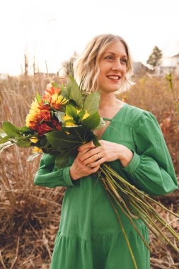 Tarlada çiçekli bir kadın