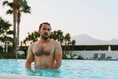 man standing in outdoor swimming pool clipart