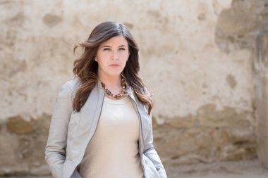 Ciddi kadınlar arka planda çatlak duvarla kameraya bakıyor.