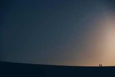 Etrafında geniş bir boşluk olan iki insan silueti.