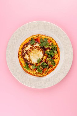 Otlar ve nohutlarla süslenmiş tabakta yassı ekmekli humus.