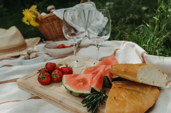 stock image Colorful picnic with food  wine glasses  straw hat in a sunny garden