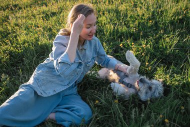 Köpeği olmayan genç bir kadın çimlerin üzerinde yatıyor.