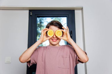 Gözlük olarak limon tutan çocuk