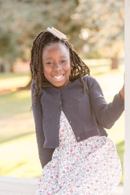 Young african american girl with twists laughing at the camera clipart