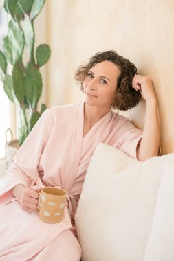 Tarafsız bir evde kanepede dinlenen kadınlar.