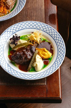 Tabakta ızgara sığır filetosu ve yanında sos.