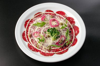 soslu, otlu ve kaparili bir tabakta mermer etli tartar.