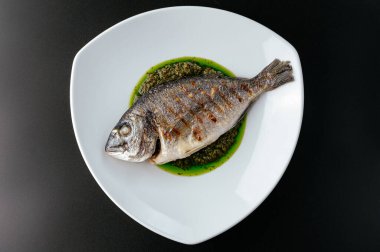 Tabağında sos olan ızgara Dorado.