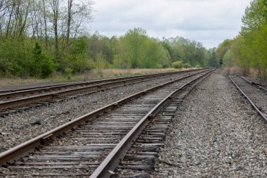 Multiple rows of bolted railroad tracks in landscape clipart