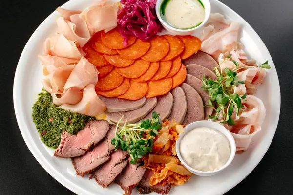 stock image various cuts of meat on a plate. a meat plate. meat appetizer