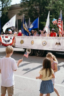 children celebrating the 4th of July at a parade clipart